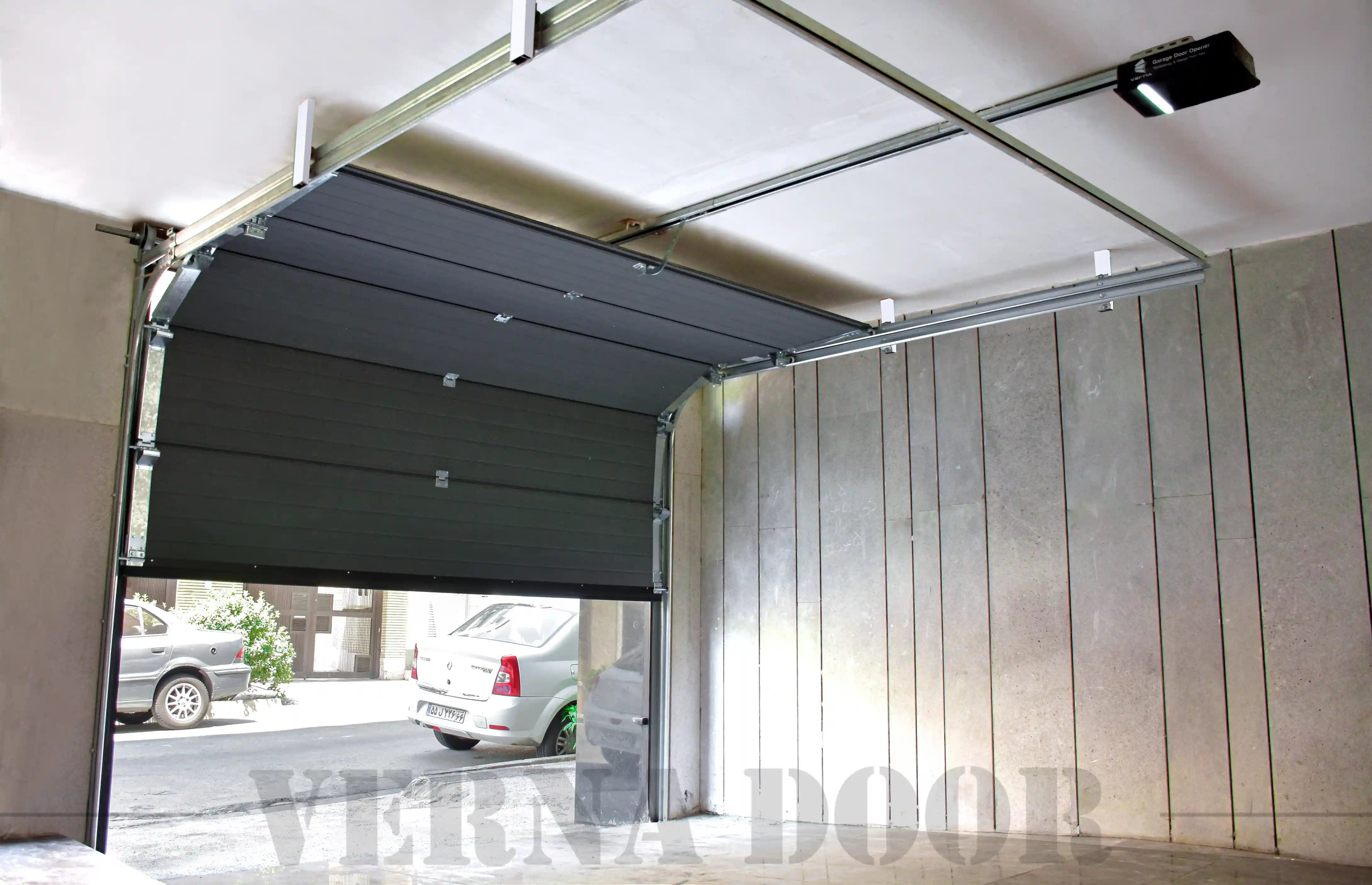 sectional garage door vernadoor with gray smooth panels installed in residential parking